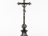une croix posée sur un socle, sur fond blanc