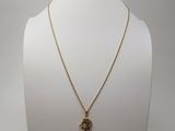 un collier plaqué or orné d'une petite tête d'éléphant, monté sur une chaîne en or