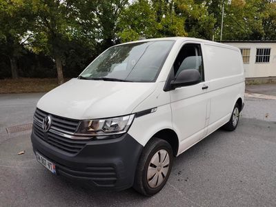 La camionnette blanche est garée sur le parking devant la maison.