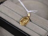 un collier en or sur lequel est gravée l'image d'une femme