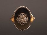 Gros plan sur une bague en or ornée d'une fleur