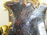a silver vase with a gold decoration on top of it