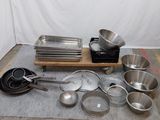 de nombreuses casseroles et poêles posées par terre