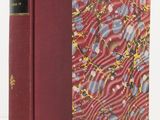 un livre à la couverture rouge posé sur une table blanche