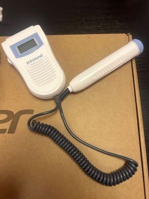 a cell phone sitting on top of a box with a cord