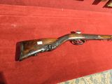 un fusil posé par terre à côté d'un tapis rouge