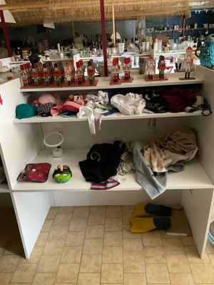 une étagère blanche sur laquelle sont posés de nombreux objets, dans une pièce