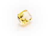 a yellow sapphire stone on a white background