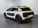 the rear of a white and black car parked in a room