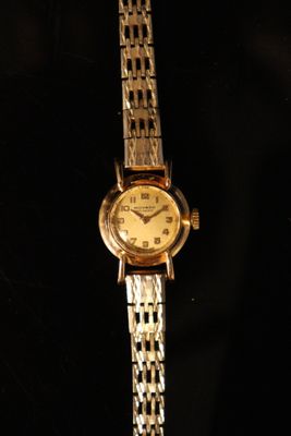 an image of a woman ' s wrist watch on a black background