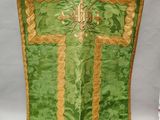 une image représentant une croix verte et dorée accrochée à un mur