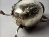 a silver object with a bird on it on a table