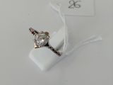 a ring with a diamond on it sitting on a white surface