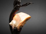 a close up of a statue of a woman holding a shell