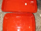 two red trays sitting on the floor next to each other