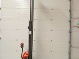 un chariot élévateur garé dans un garage dont la porte est ouverte