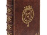 un vieux livre relié en cuir orné d'un emblème doré