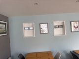 a table and chairs in a room with pictures on the wall
