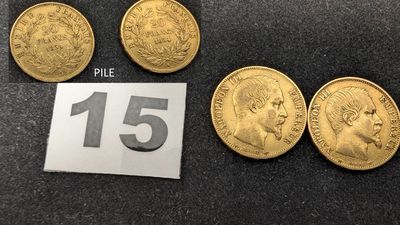 un gros plan sur plusieurs pièces d'or posées sur une table