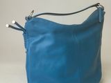 a blue purse sitting on top of a table next to a white wall