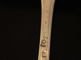 a silver spoon with a picture on it sitting on a table