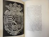 an open book with a picture of a coat of arms on it