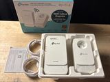 a box with two wifi routers and a charger on the table