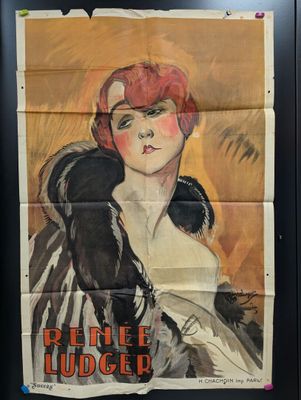 une vieille affiche représentant une femme aux cheveux roux, dans un cadre noir