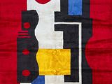 un tapis rouge orné de motifs noirs, jaunes, bleus et rouges