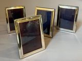 three silver and black picture frames sitting on a white table
