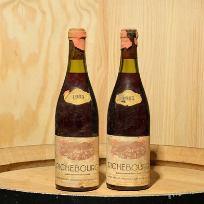 two bottles of wine sitting on top of a barrel