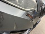 a close up of the front of a car with a dent in it