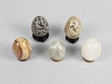 four different types of marble eggs on a white surface