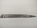 a close up of a knife with writing on it on a table