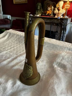 une trompette en laiton posée sur une table dans un salon