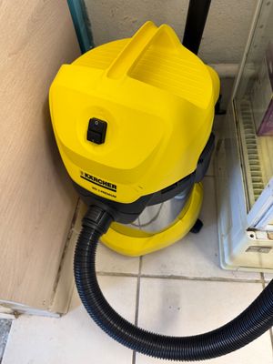 a yellow vacuum that is sitting in the corner of a room
