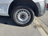 a white car with a flat tire parked on the side of the road