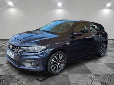 a blue car is parked on a checkered floor in a garage
