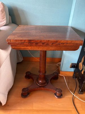 a small table with a wooden top on a hard wood floor