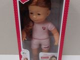 barbie doll with red hair and pink outfit in pink box