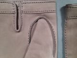 pair of beige leather driving gloves on a blue surface
