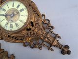 a gold clock on a white table next to a mirror