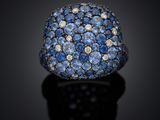 a close up of a ring with blue sapphires and diamonds