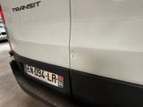 a white van parked in a parking lot next to other cars
