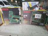 deux cartons d'outils électriques Bosch posés sur une table dans un garage