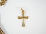 a gold cross and a gold chain on a white surface
