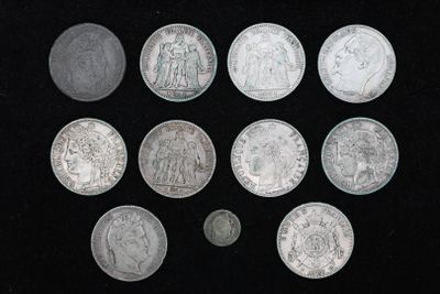 Plusieurs pièces d'argent sont disposées en cercle sur une surface noire