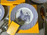 a place setting with blue and white plates, silverware, and silverware
