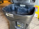 a black trash can sitting on the floor in a garage