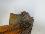 un banc en bois sur lequel est sculpté un bateau